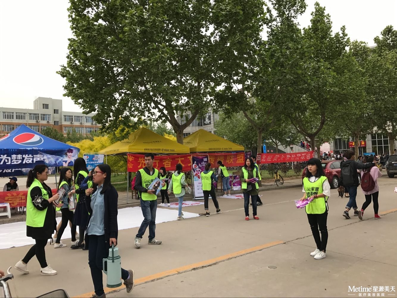 现场活动人员对同学们派发活动单页